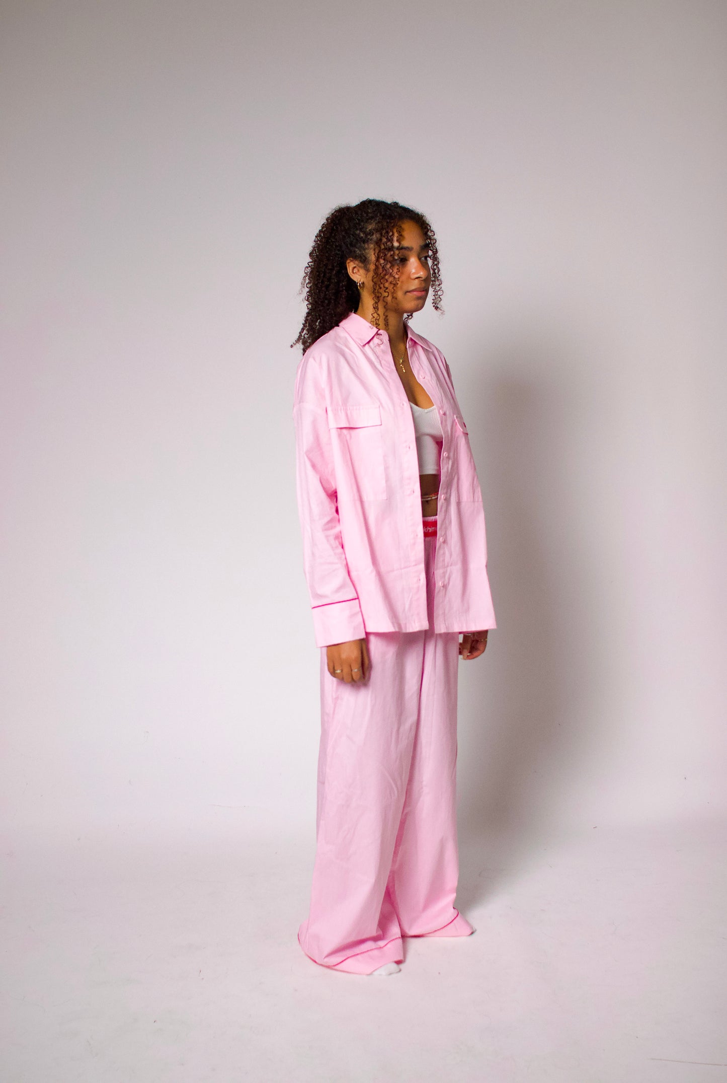 Femme portant un pyjama oversize en coton, assise sur un canapé avec un livre.
Pyjama en coton rose porté par une femme, ambiance cosy et relaxante.
Look loungewear chic : ensemble en coton naturel, parfait pour une soirée cocooning.